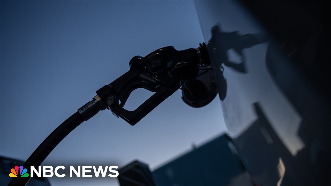 Fuel pump nozzle fueling a vehicle at dusk with NBC News logo in the lower-left corner.
